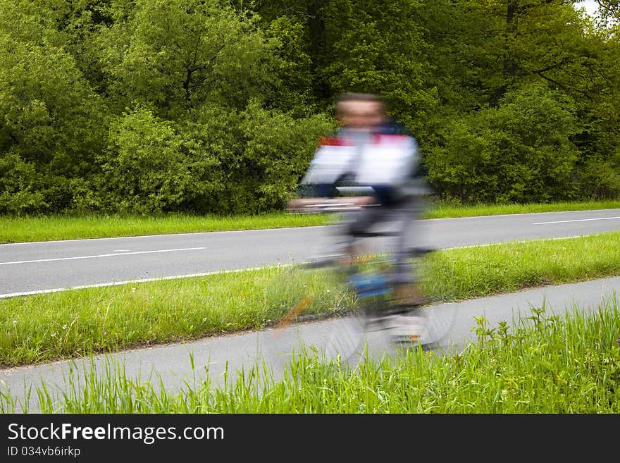 Blurred Man Riding Bicycles Along a Country Road