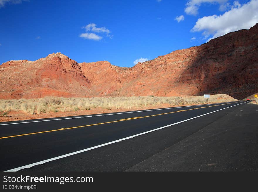 Road with red desert mountain and Cloudy Blue Skies in america