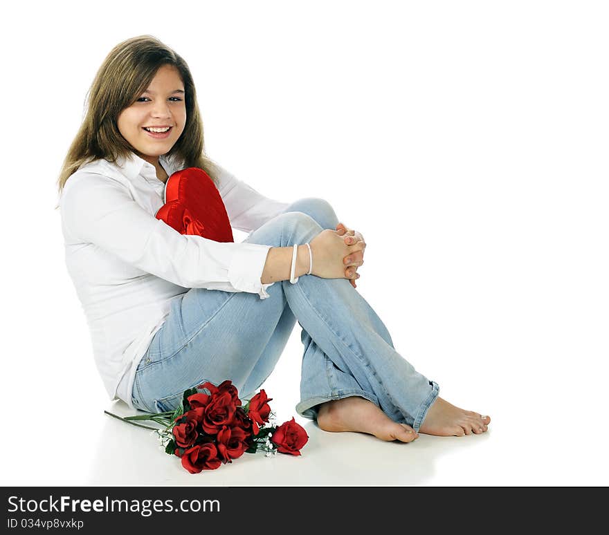 A beautiful young teen happy with her heart-shaped box of chocolates and a bouquet of red roses.  Isolated on white. A beautiful young teen happy with her heart-shaped box of chocolates and a bouquet of red roses.  Isolated on white.