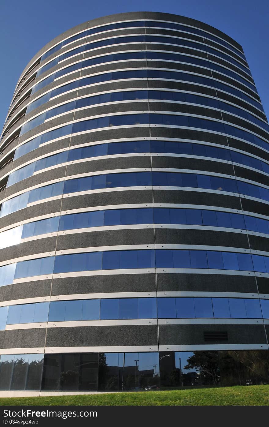 Large round office building with grass and blue sky. Large round office building with grass and blue sky.