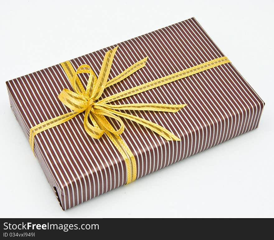 Black gift box with white bar attached gold ribbon on white background.