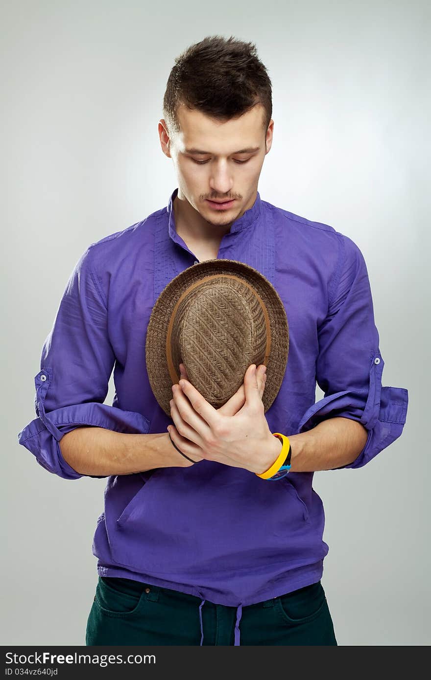 Portrait of a handsome caucasian man praying and holding a hat in his hands