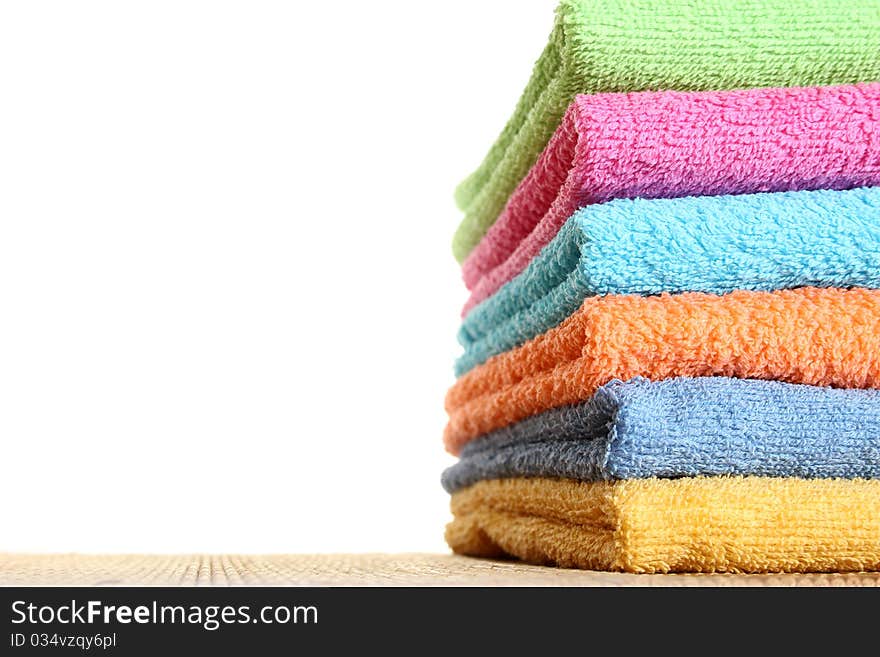 Lots of colorful bath towels stacked on each other. Isolated