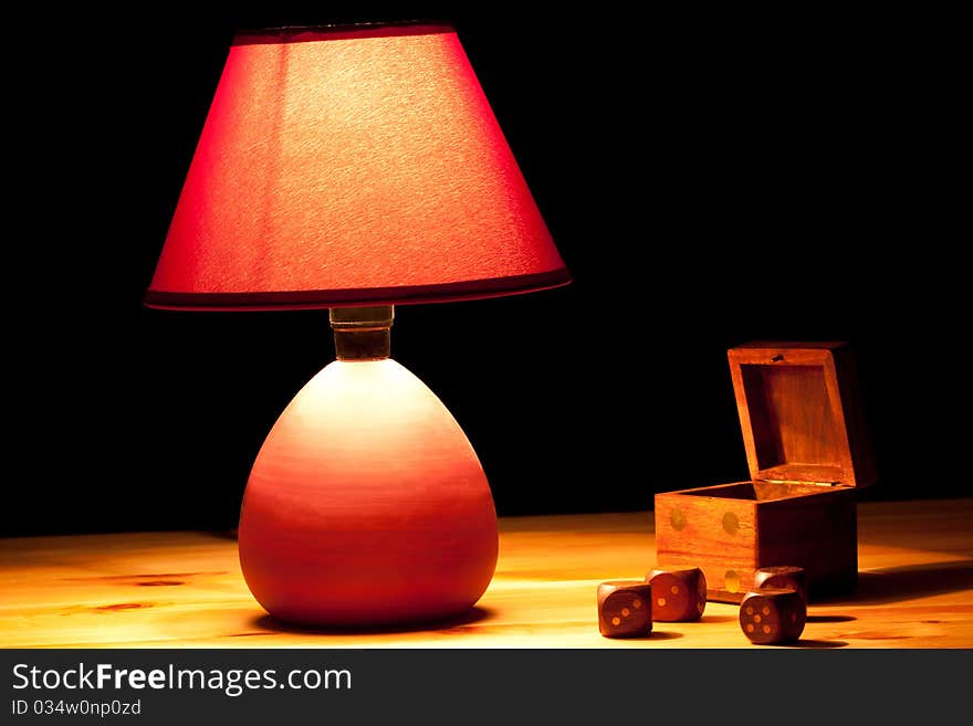 Lamp illuminating wooden dice on table. Lamp illuminating wooden dice on table