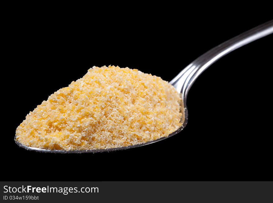 Corn on spoon with black isolated background