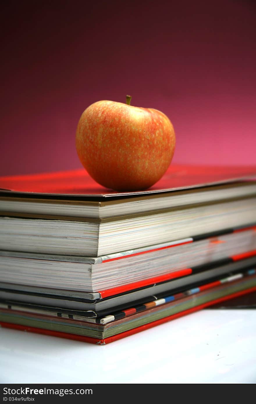 Red apple resting on the book with chalk board as background. Red apple resting on the book with chalk board as background