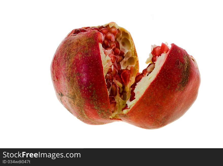 Mature pomegranate which have broken on two half (focus on the foreground, isolated)