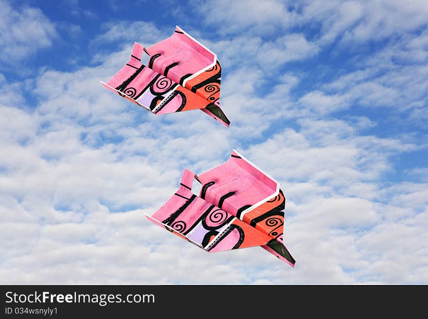 Two colored paper plane against winter clouds. Two colored paper plane against winter clouds