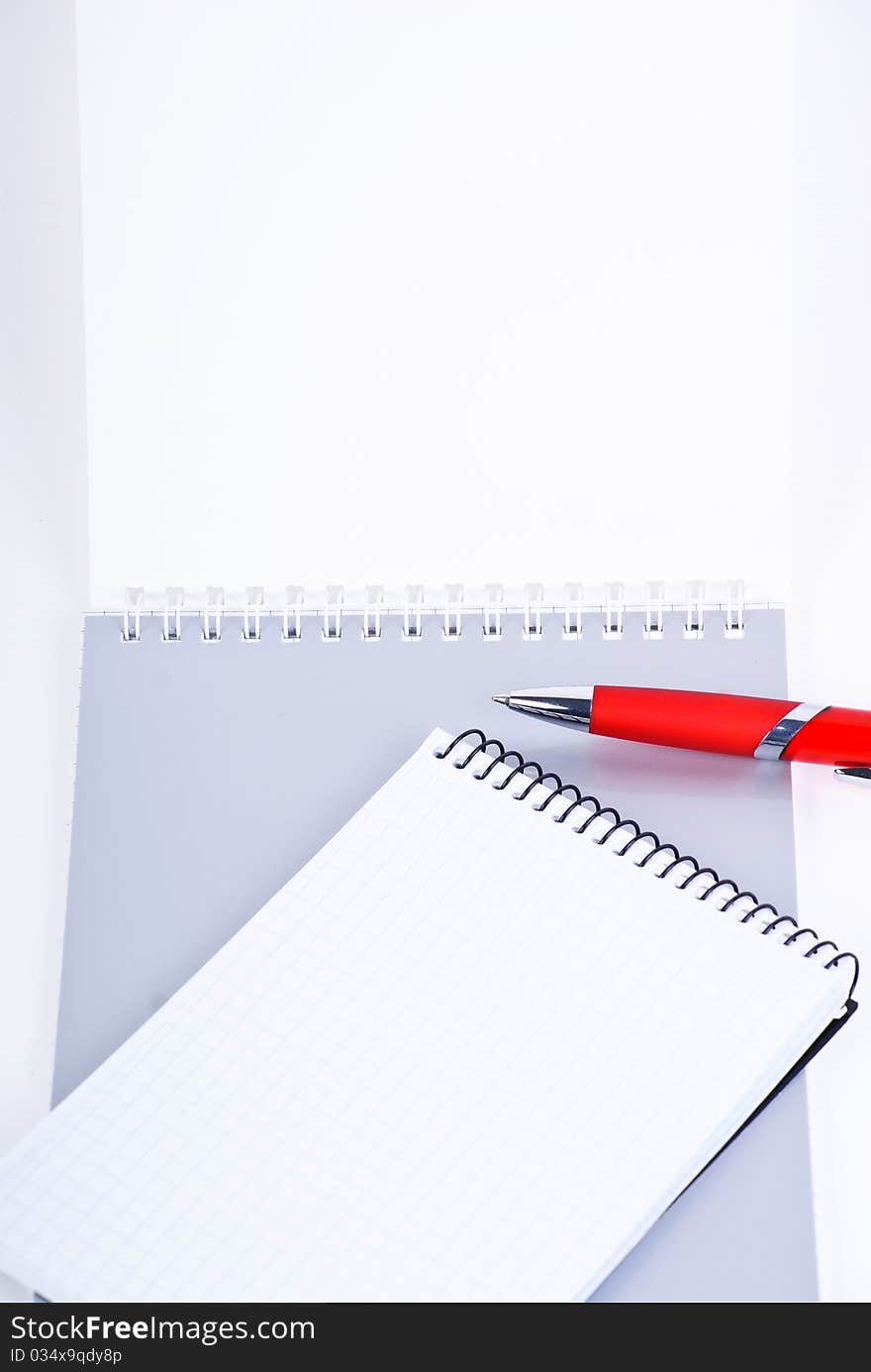 A red pen on a notebook, isolated in white background.