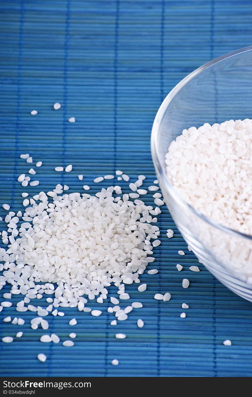 White rice in a glass dish on blue background