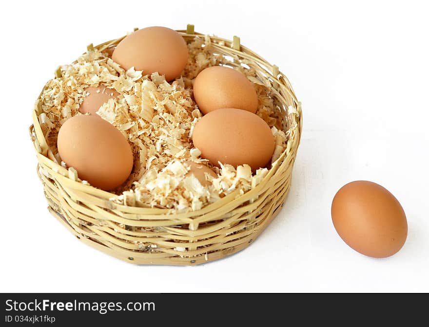 Chicken eggs in a straw basket with wood shreds to remove humidity. Chicken eggs in a straw basket with wood shreds to remove humidity.