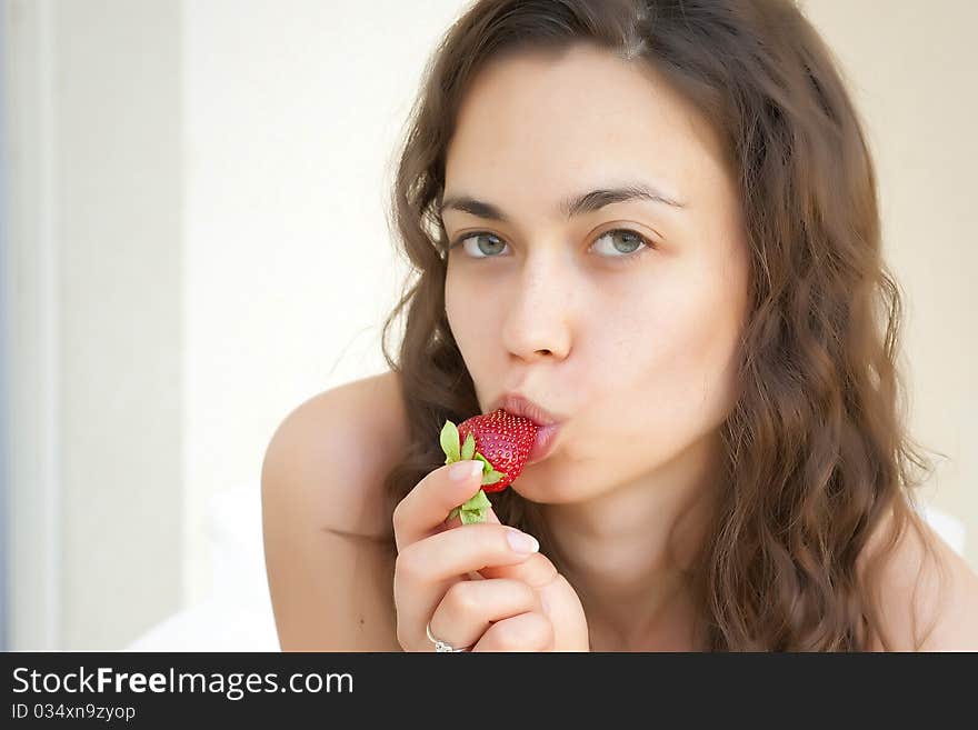 The girl the brunette eats an appetizing berry a s