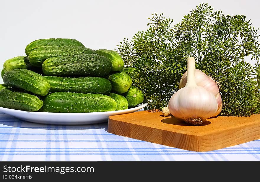 Fresh cucumbers, garlic and dill on a table.