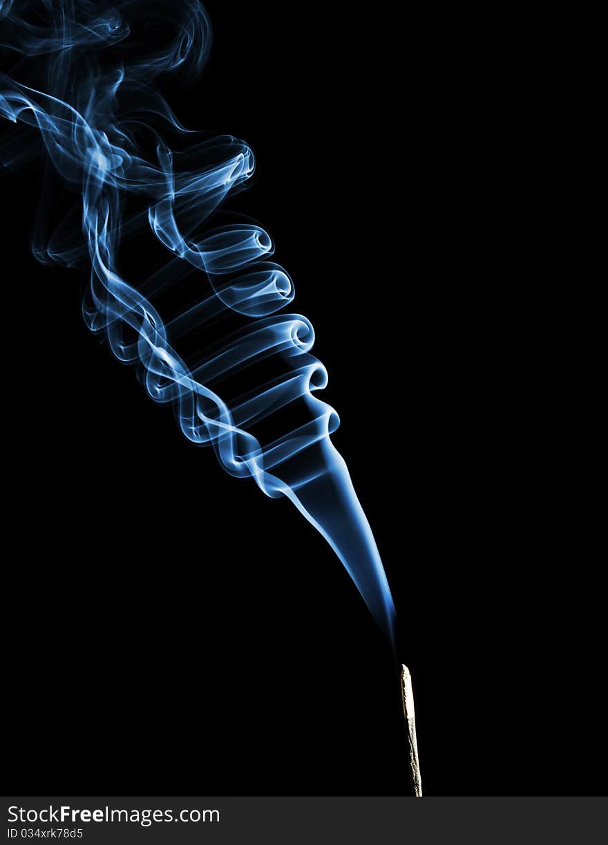 Rising blue smoke on black background