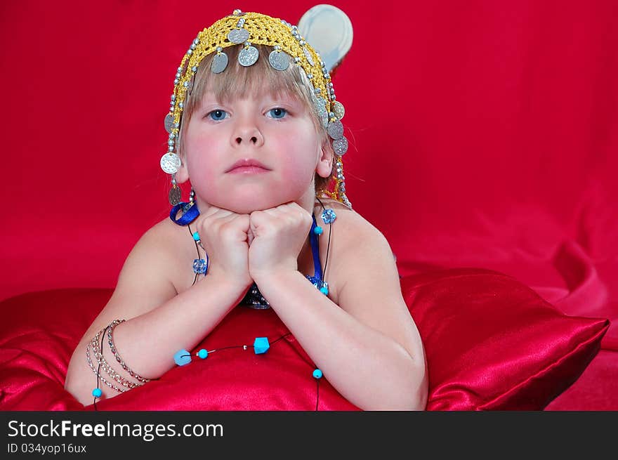 Little girl in oriental costume on a red background