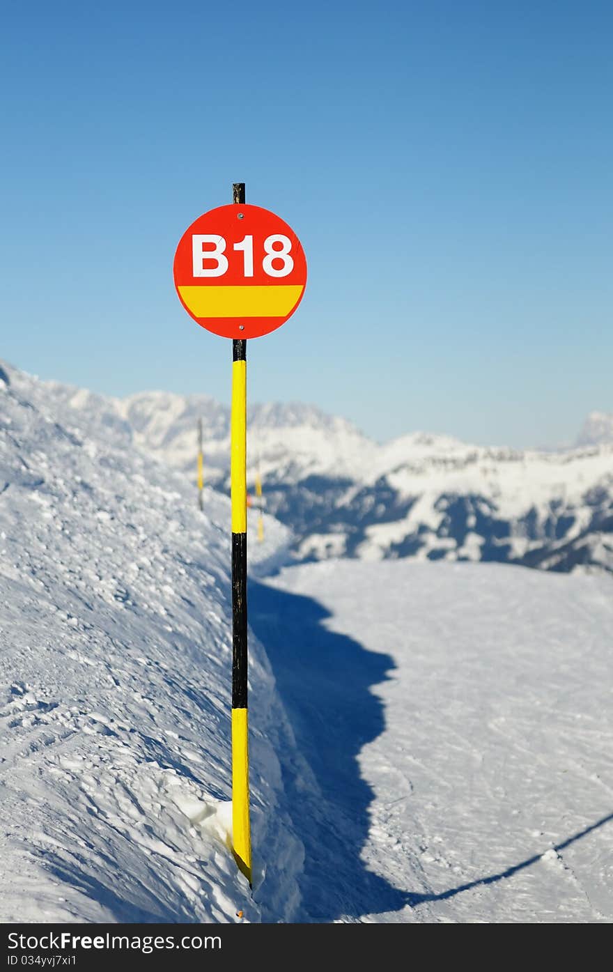 Route index on red round sign with yellow and black stick placed in mountains of Austria. Route index on red round sign with yellow and black stick placed in mountains of Austria