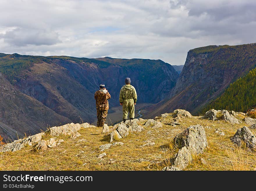 Tourists at precipice in mountains, Altai, Siberia, Russia. Tourists at precipice in mountains, Altai, Siberia, Russia