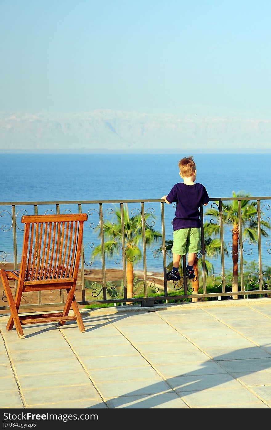 Kid climbed fence of a balcony. Kid climbed fence of a balcony