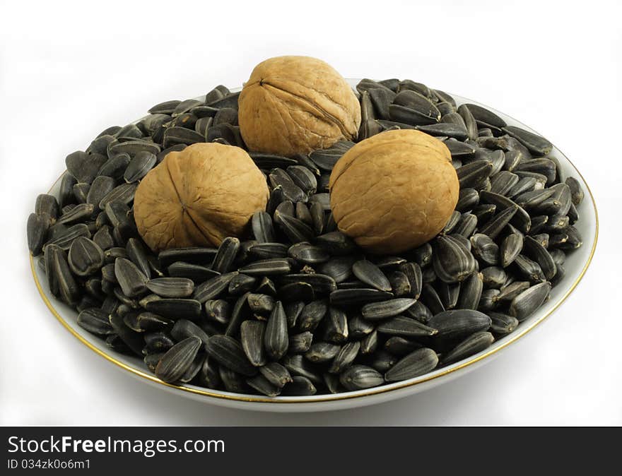 Three walnuts and sunflower seeds on a saucer