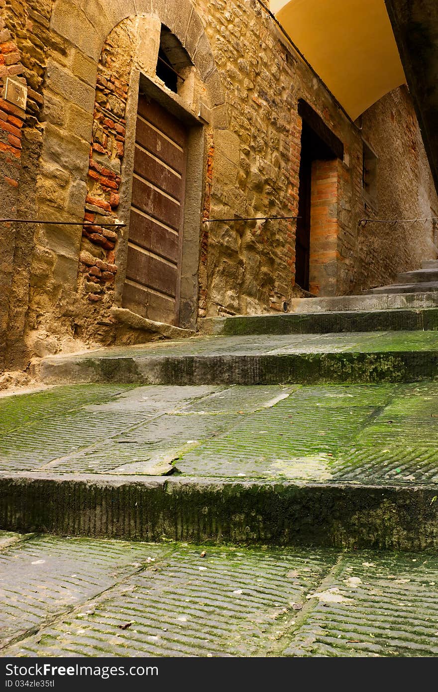 Dirty alley with staircase and vault, narrow dark grunge decadent lane in the old town