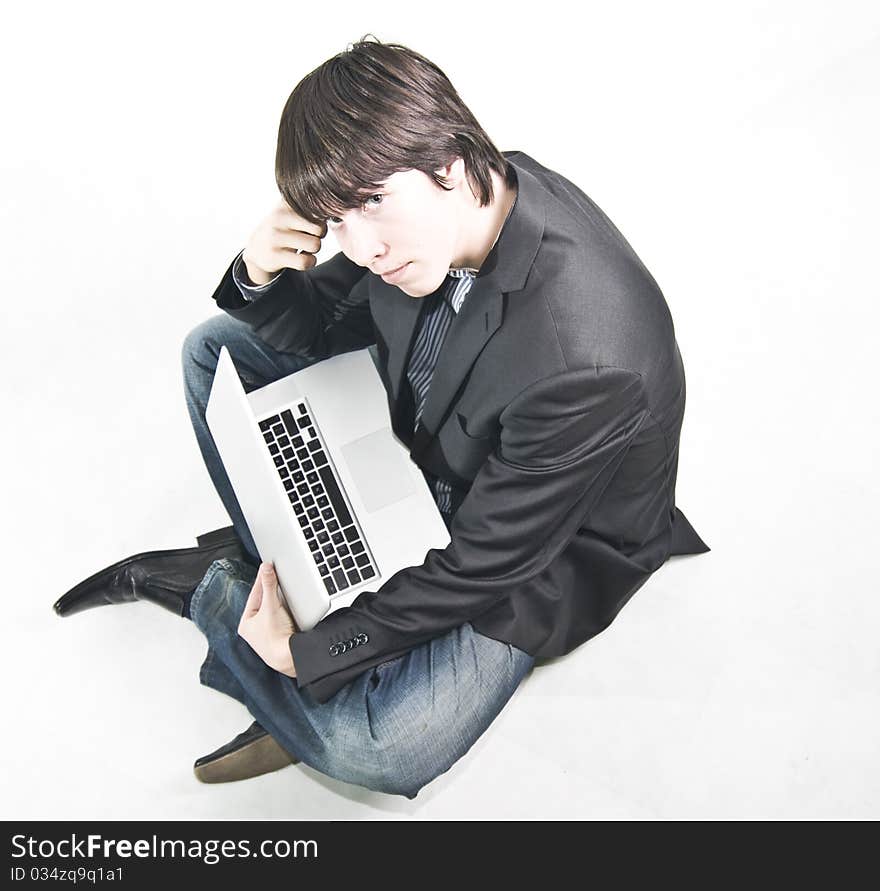 Young businessman in suit sitting on the floor