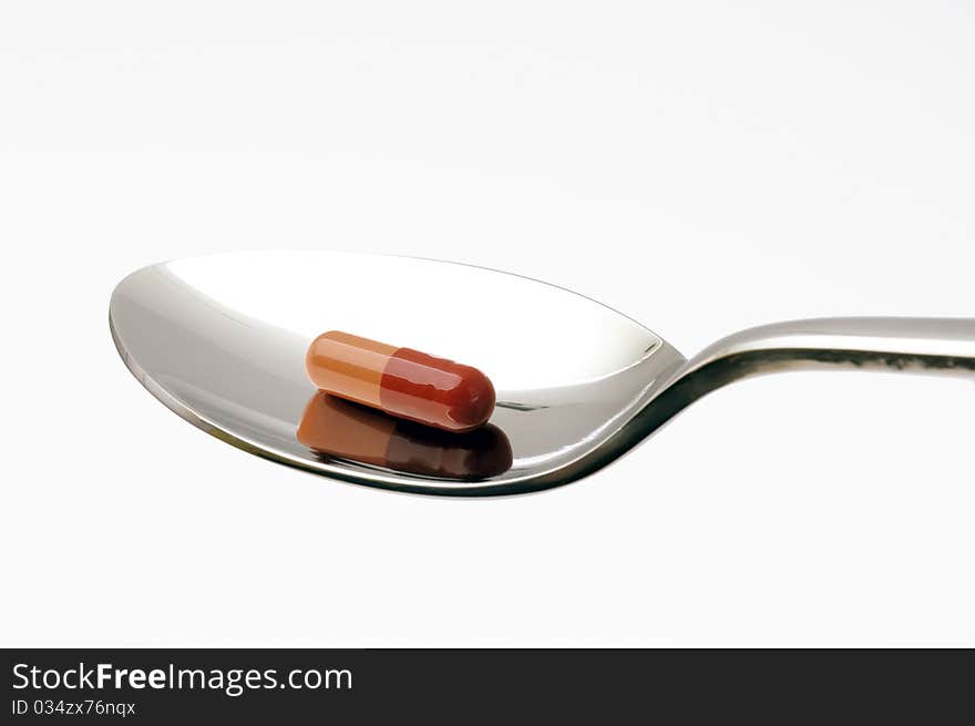 A spoon with a pill