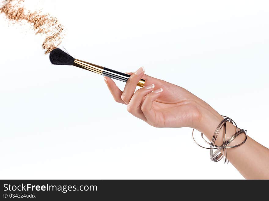 Close up view of woman’s hand holding brush on color back. Close up view of woman’s hand holding brush on color back