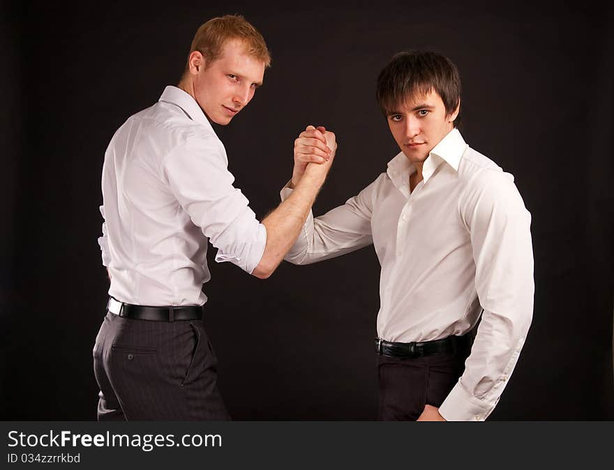 Portrait two adult man in business hand shake on black backdrop