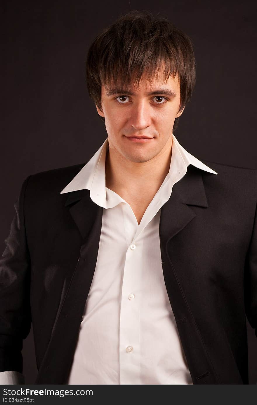 Portrait strong adult man with charming sight on a black backdrop