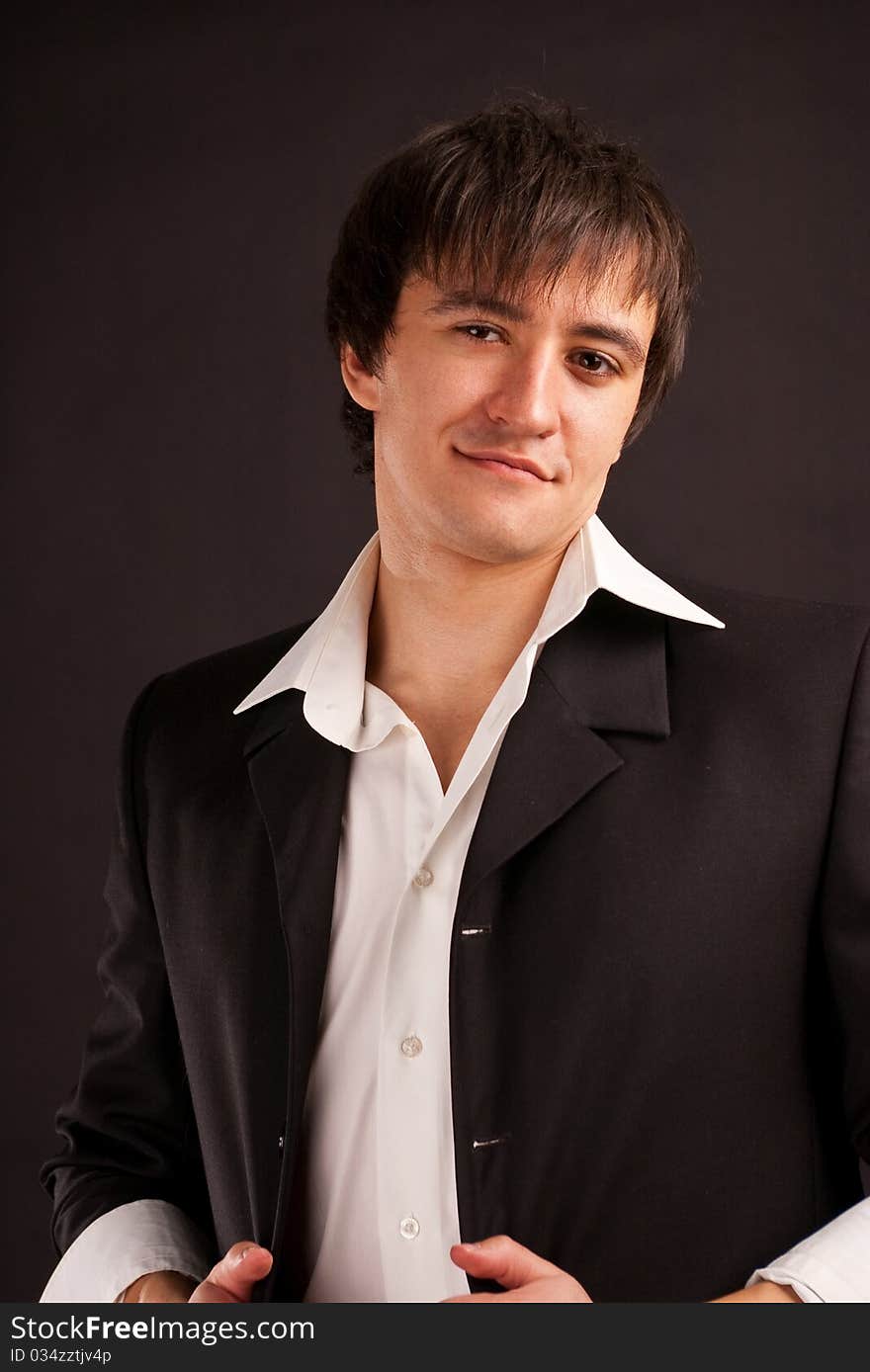 Portrait strong adult man with charming sight on a black backdrop