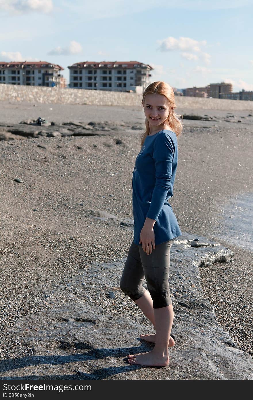 Girl in a dress on a beach with pebbles