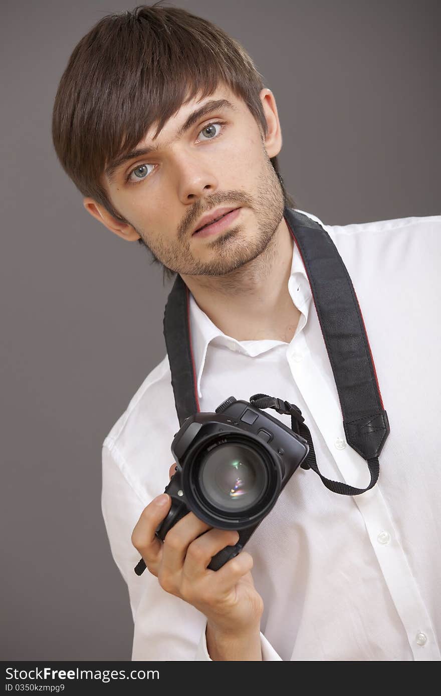 Male photographer with camera over grey background