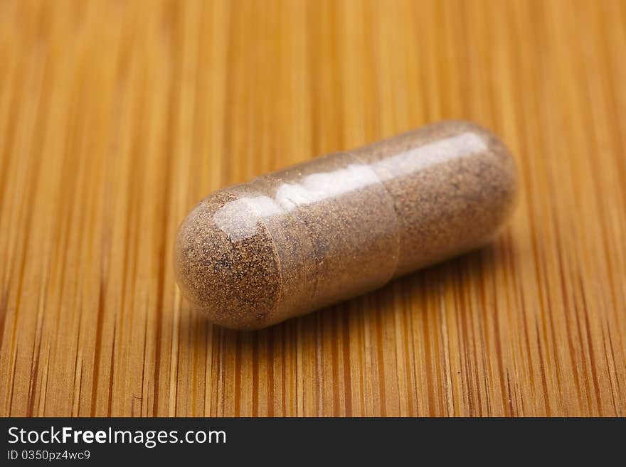 Medical pill against diseases on a wooden table.