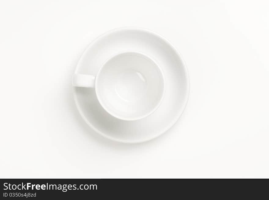 Cup and plate prepared for drinking on a white background.