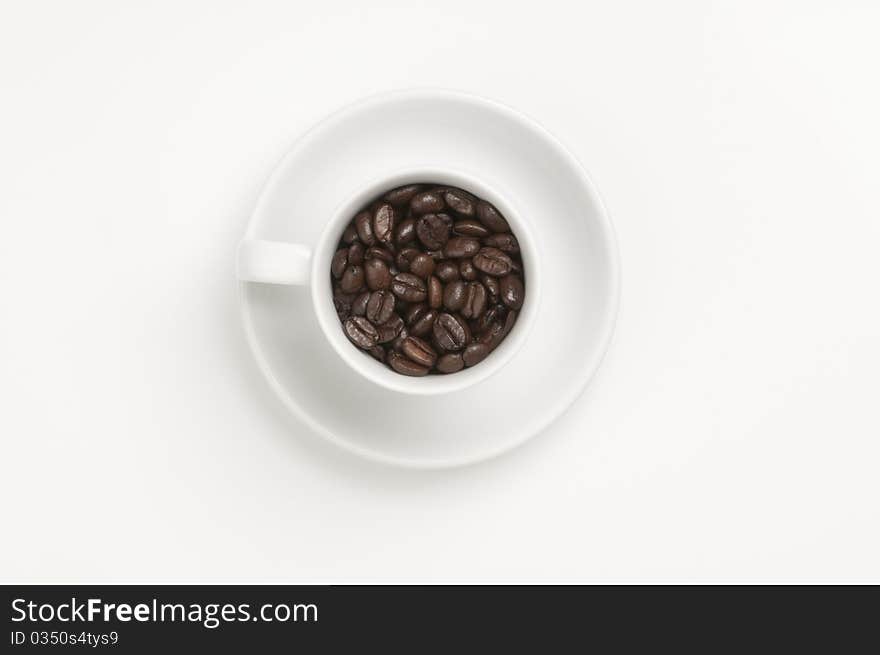 White coffee cup with plate and coffee beans. White coffee cup with plate and coffee beans.