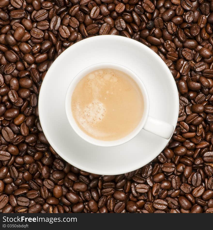 Cup and plate prepared for drinking on a coffee bean background. Cup and plate prepared for drinking on a coffee bean background.