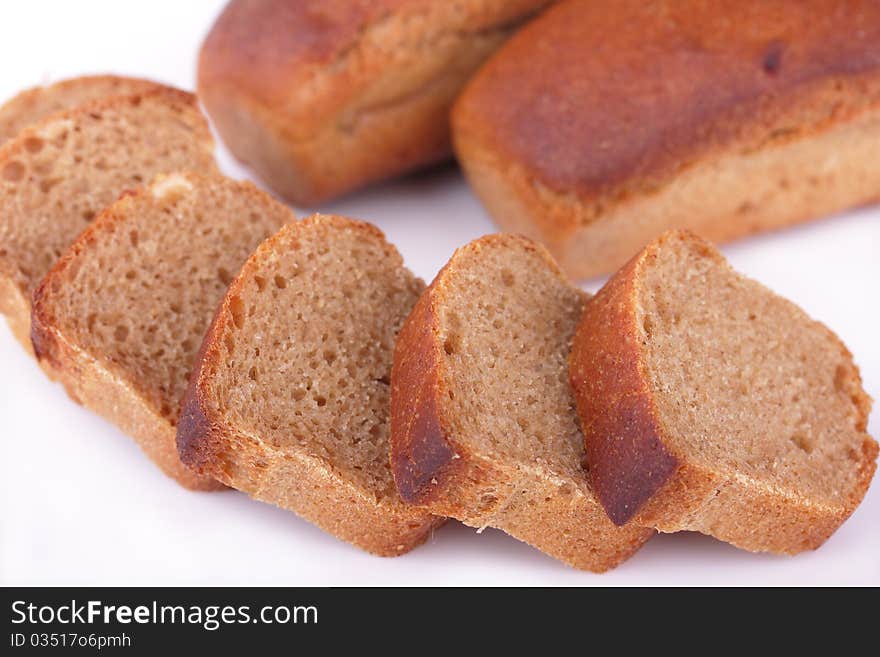 Fresh baked homemade loafs of rye bread and slices of cut rye bread isolated on white background. Fresh baked homemade loafs of rye bread and slices of cut rye bread isolated on white background