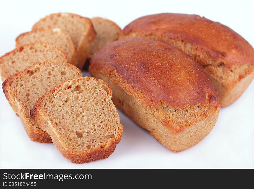 Fresh baked homemade loafs of rye bread and slices of cut rye bread isolated on white background. Fresh baked homemade loafs of rye bread and slices of cut rye bread isolated on white background