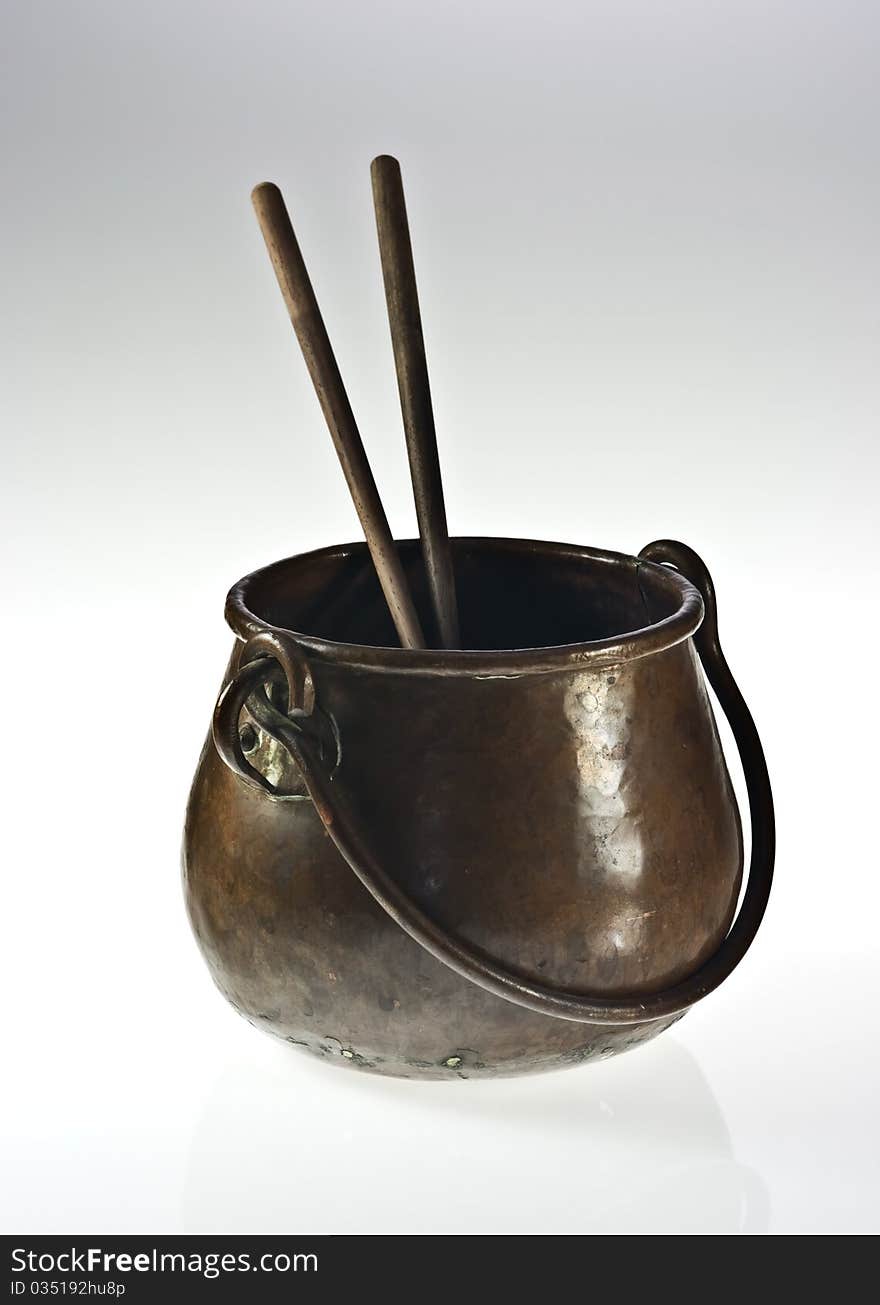 Old copper pot with two chopsticks on white. Old copper pot with two chopsticks on white