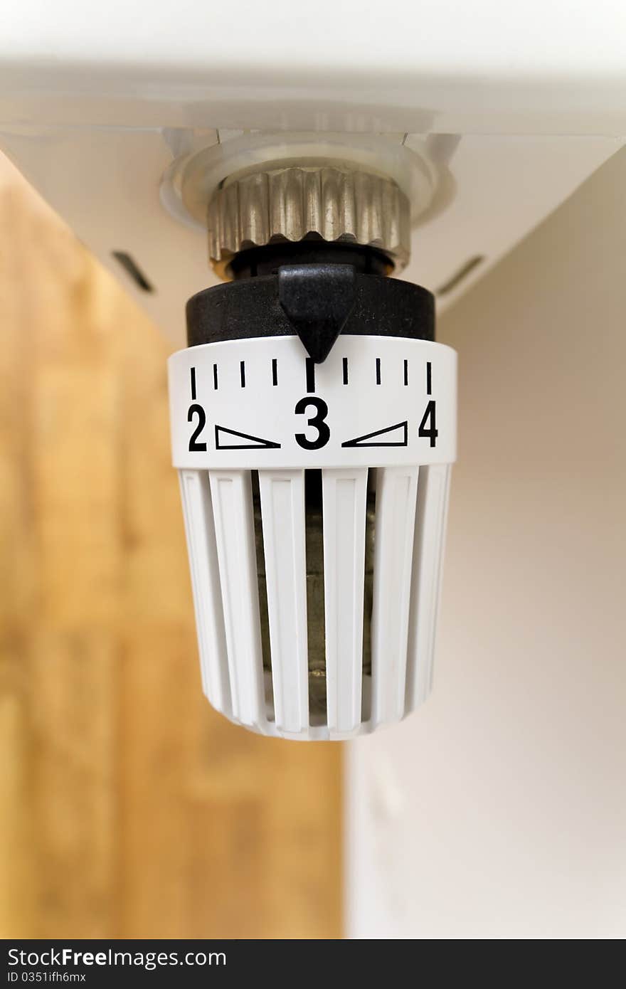 White thermostat on a radiator with numbers. White thermostat on a radiator with numbers