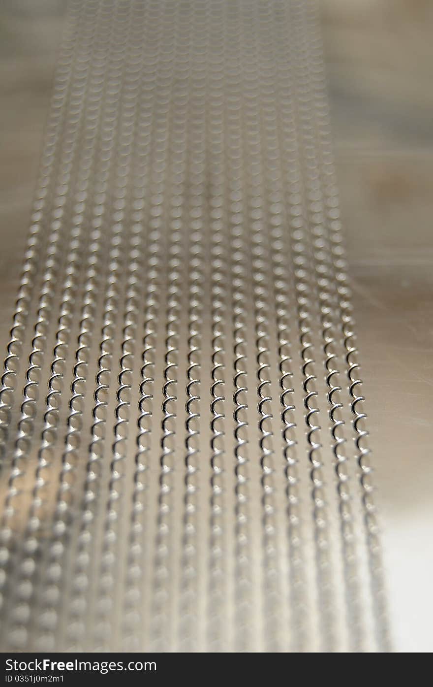 Closeup of snares on the backside of a snare drum. These are little metal springs that pop when the head is struck with a drum stick. Closeup of snares on the backside of a snare drum. These are little metal springs that pop when the head is struck with a drum stick.