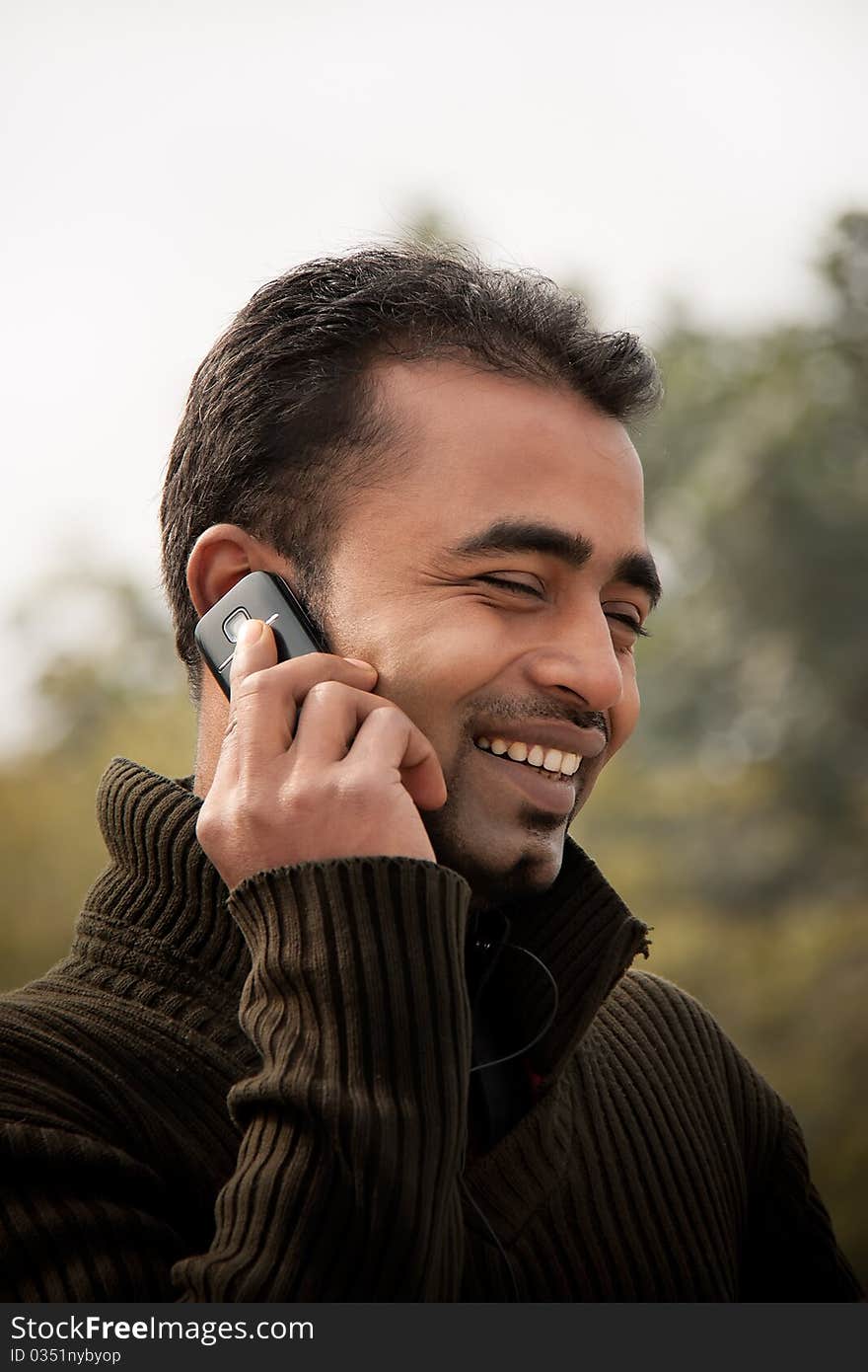 Portrait of a happy Indian businessman talking at cell phone. Portrait of a happy Indian businessman talking at cell phone