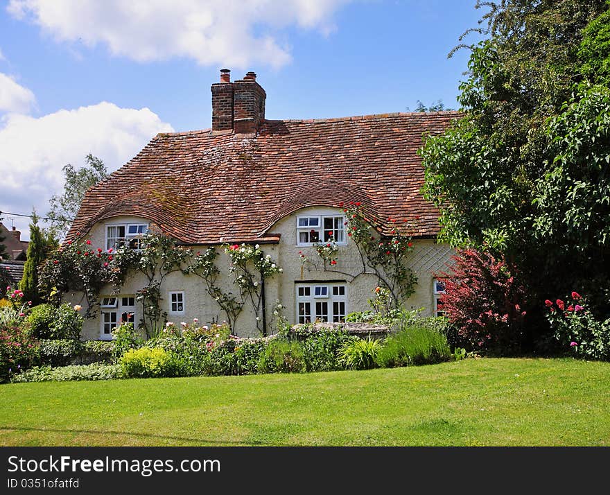 Traditional English Village Cottage and garden with Climbing roses on the Wall