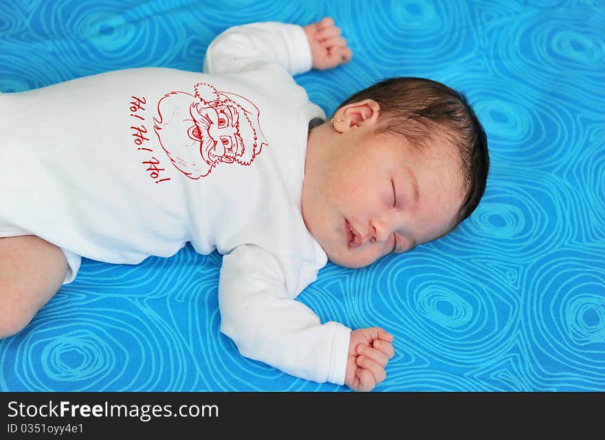 Baby girl of 21 days old sleeping on blue background. Baby girl of 21 days old sleeping on blue background