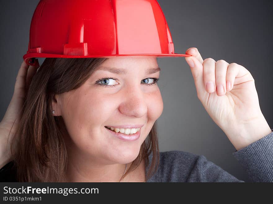 Portrait of young architect wearing red hardhat, looking at camera and smiling. Portrait of young architect wearing red hardhat, looking at camera and smiling