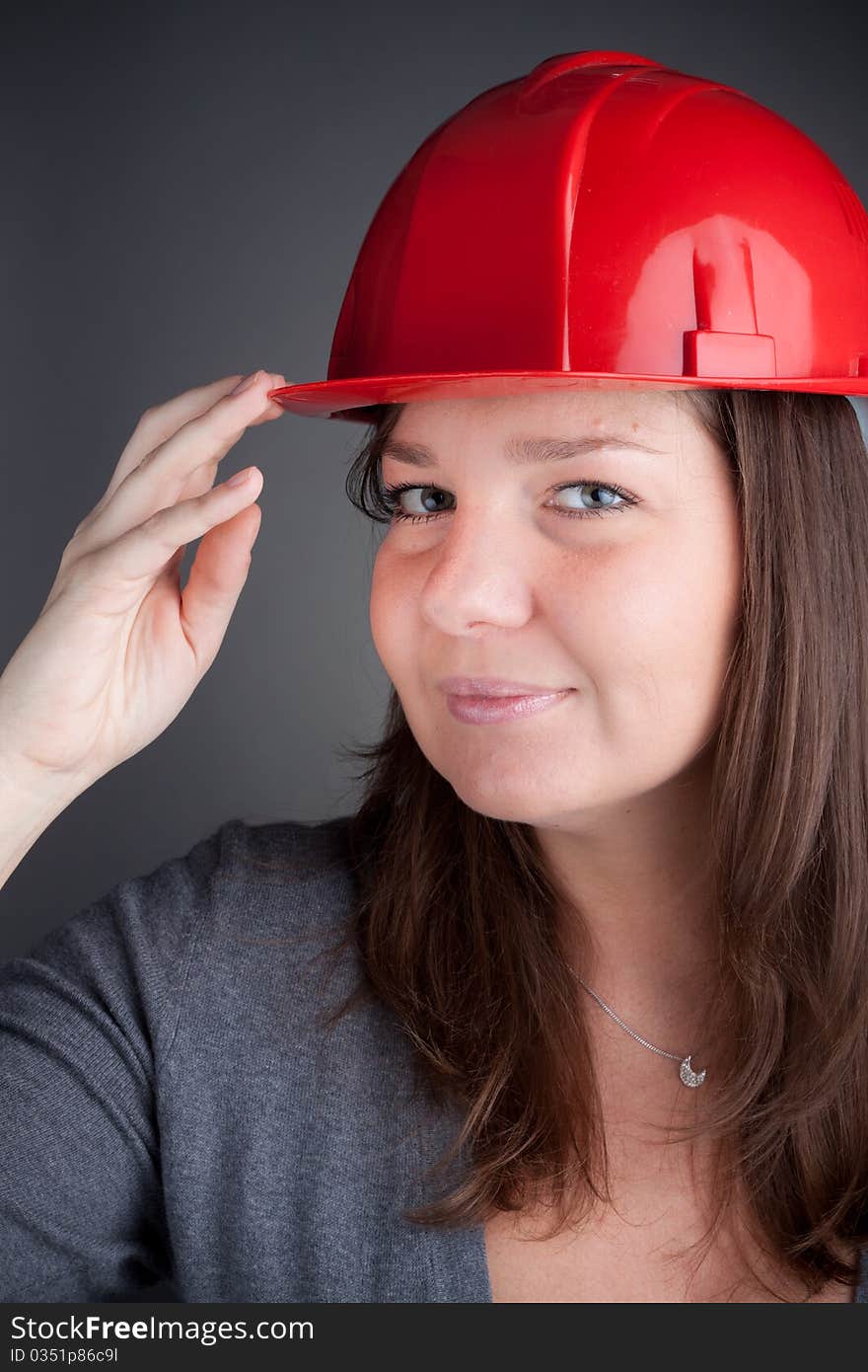 Portrait of young architect wearing red hardhat, looking at camera and smiling. Portrait of young architect wearing red hardhat, looking at camera and smiling