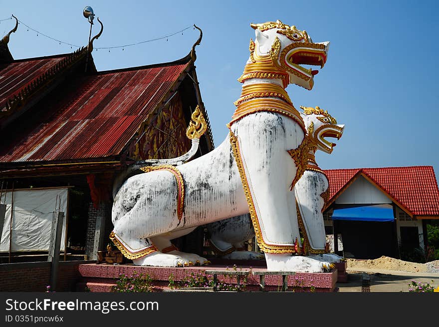 Antique guardian lion sculpture in front of the temple, thailand