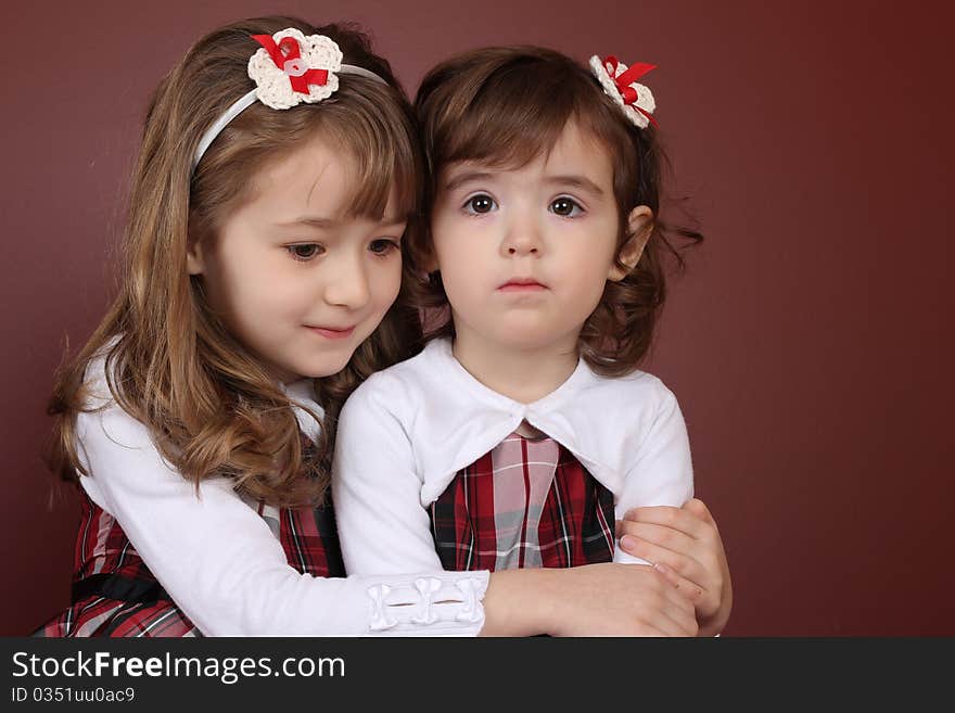 Two cute little sisters wearing Christmas dresses. Two cute little sisters wearing Christmas dresses