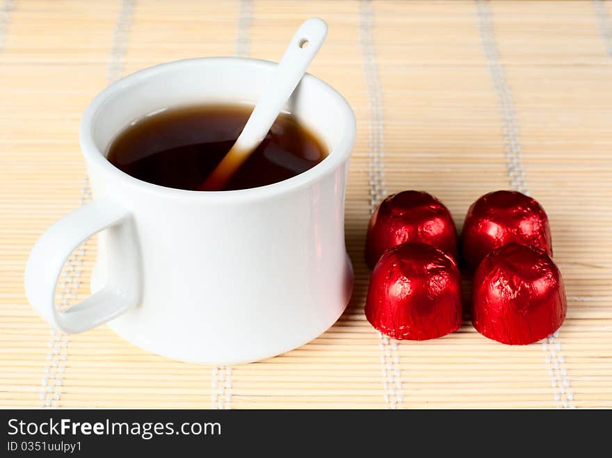 A cup of tea with sweets.