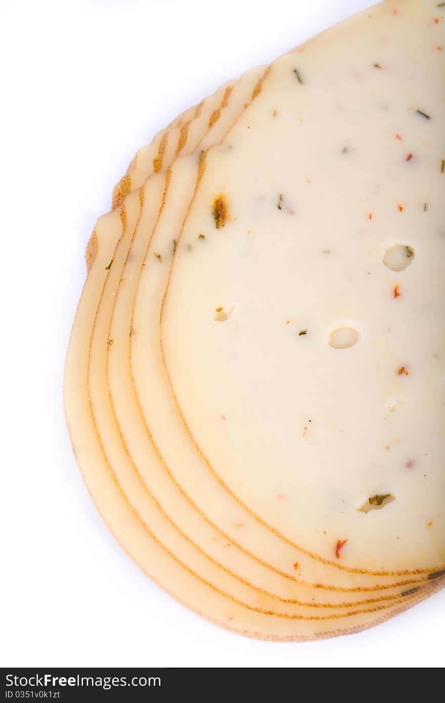 Cheese slices with spices on a white background.